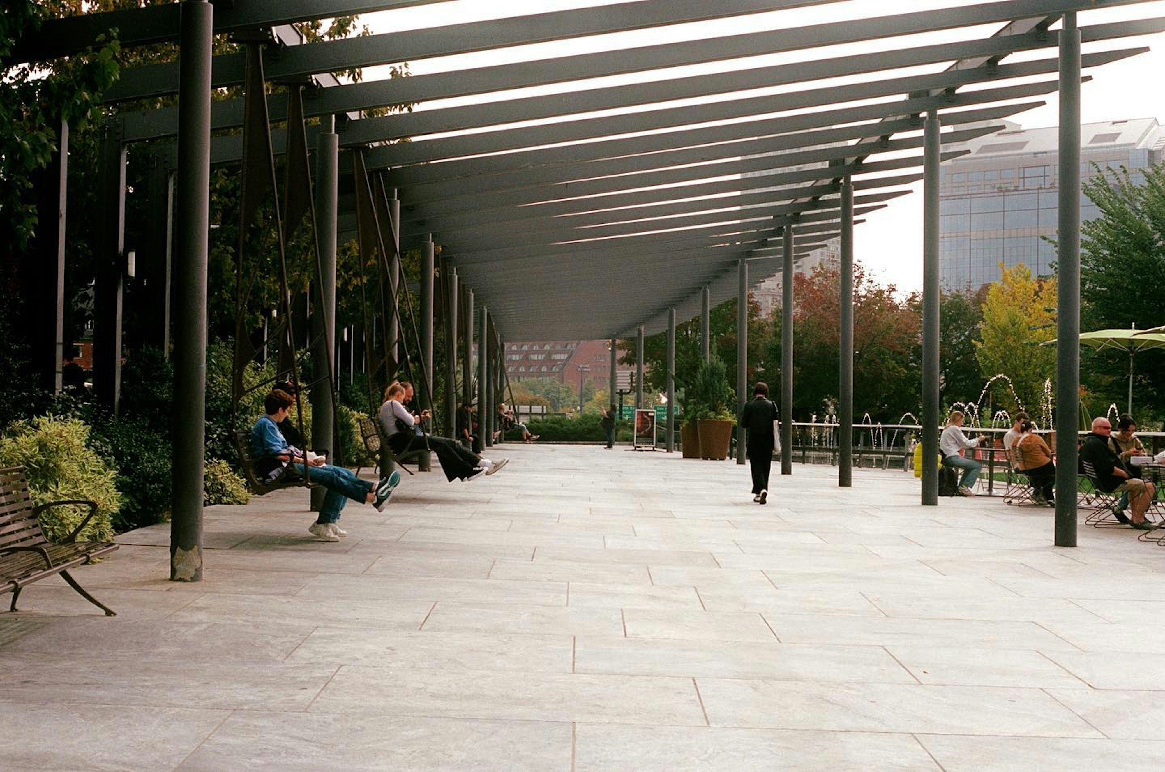 A group of people sitting on benches under a canopy