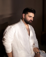 A man with a beard sitting on a bed