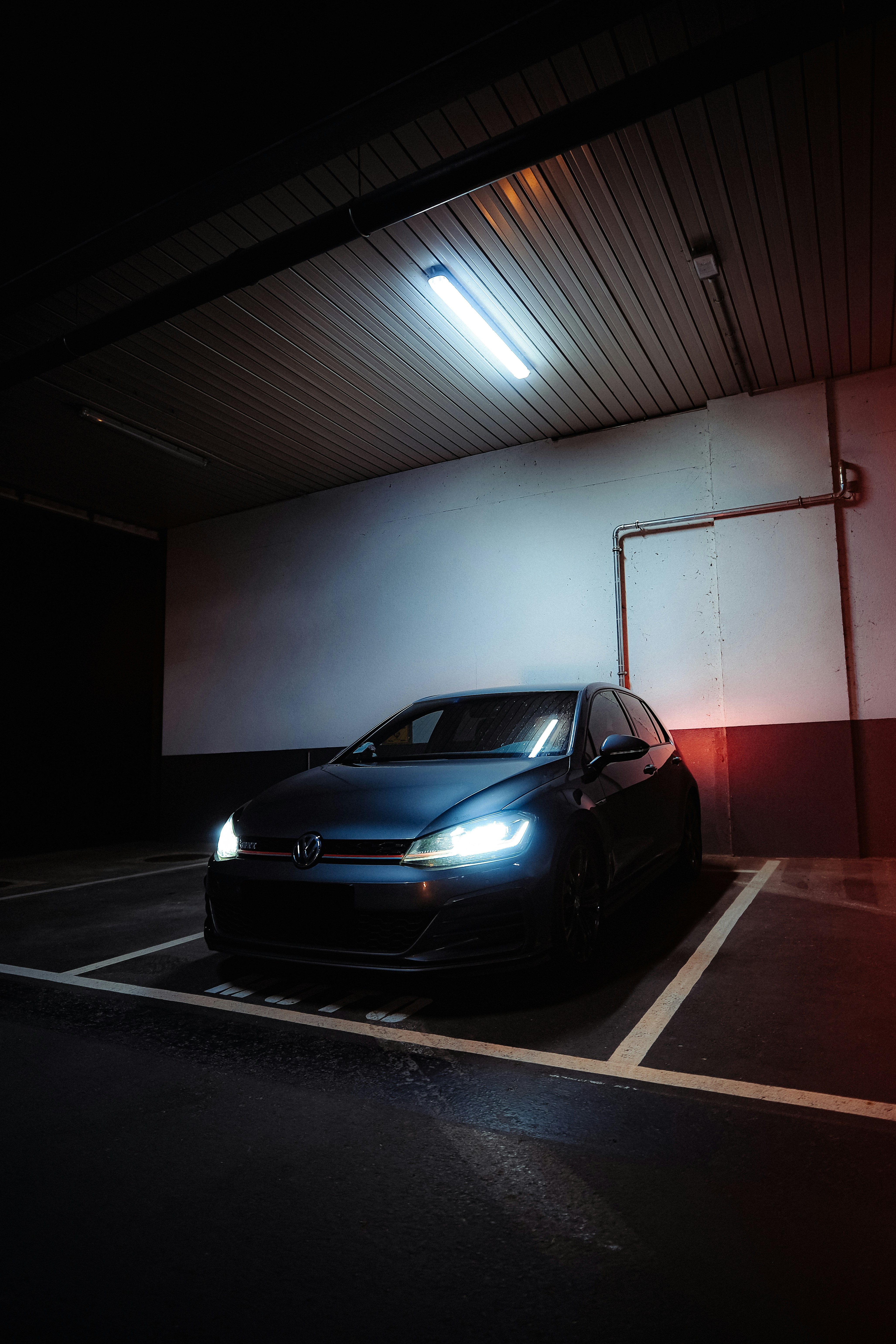 A car parked in a parking lot at night