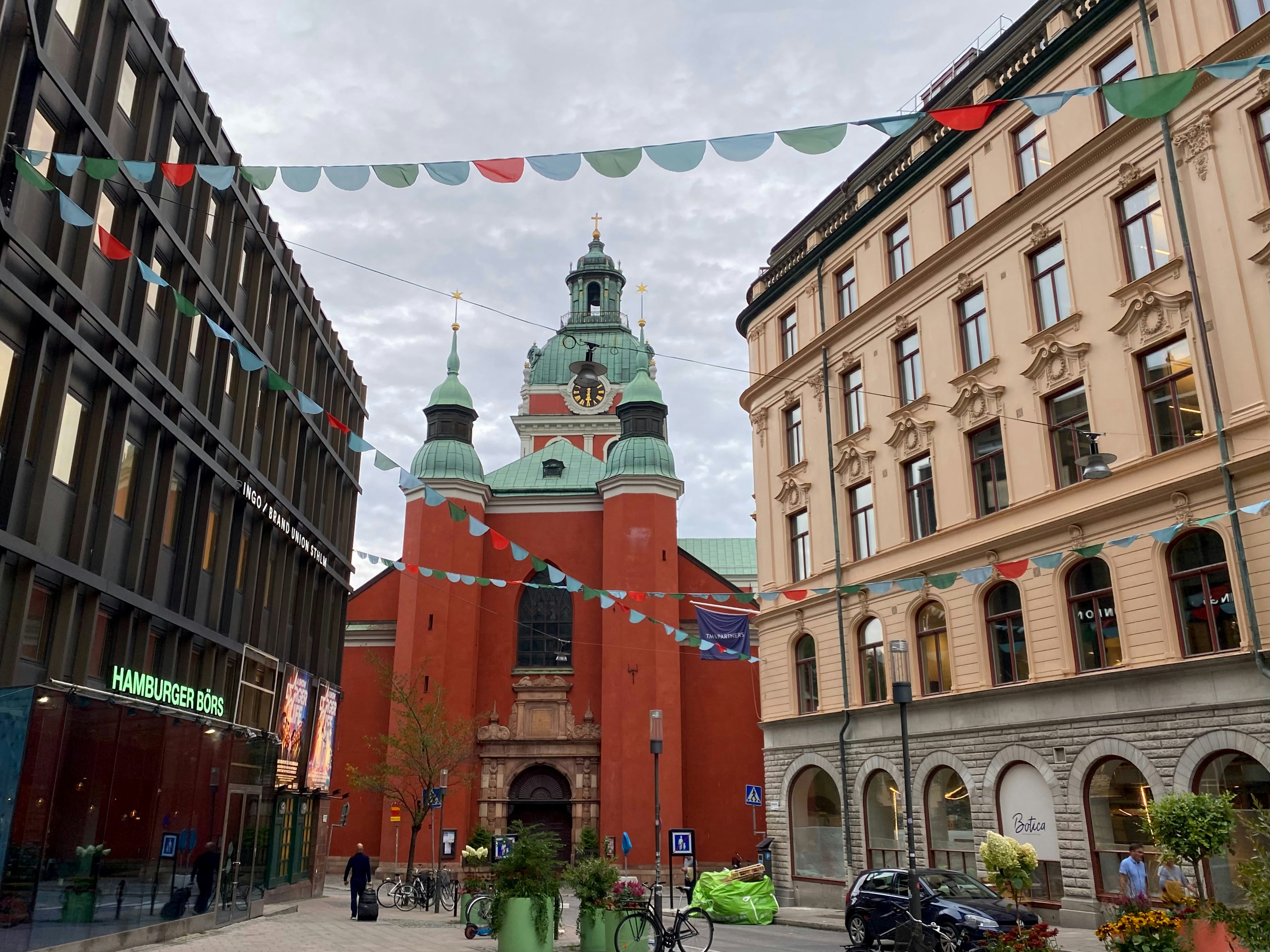 A group of people walking down a street next to tall buildings