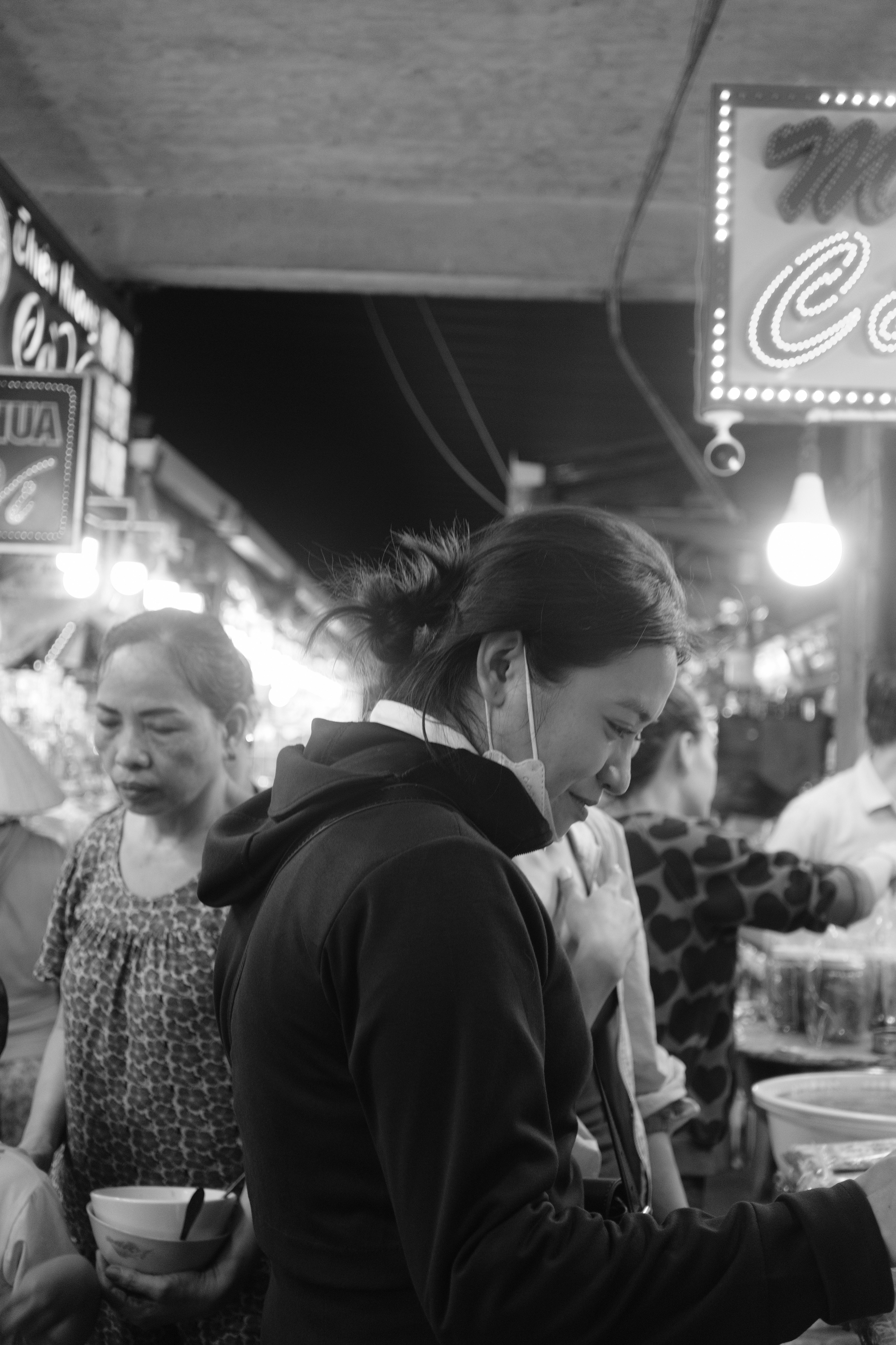 A group of people standing around a food stand