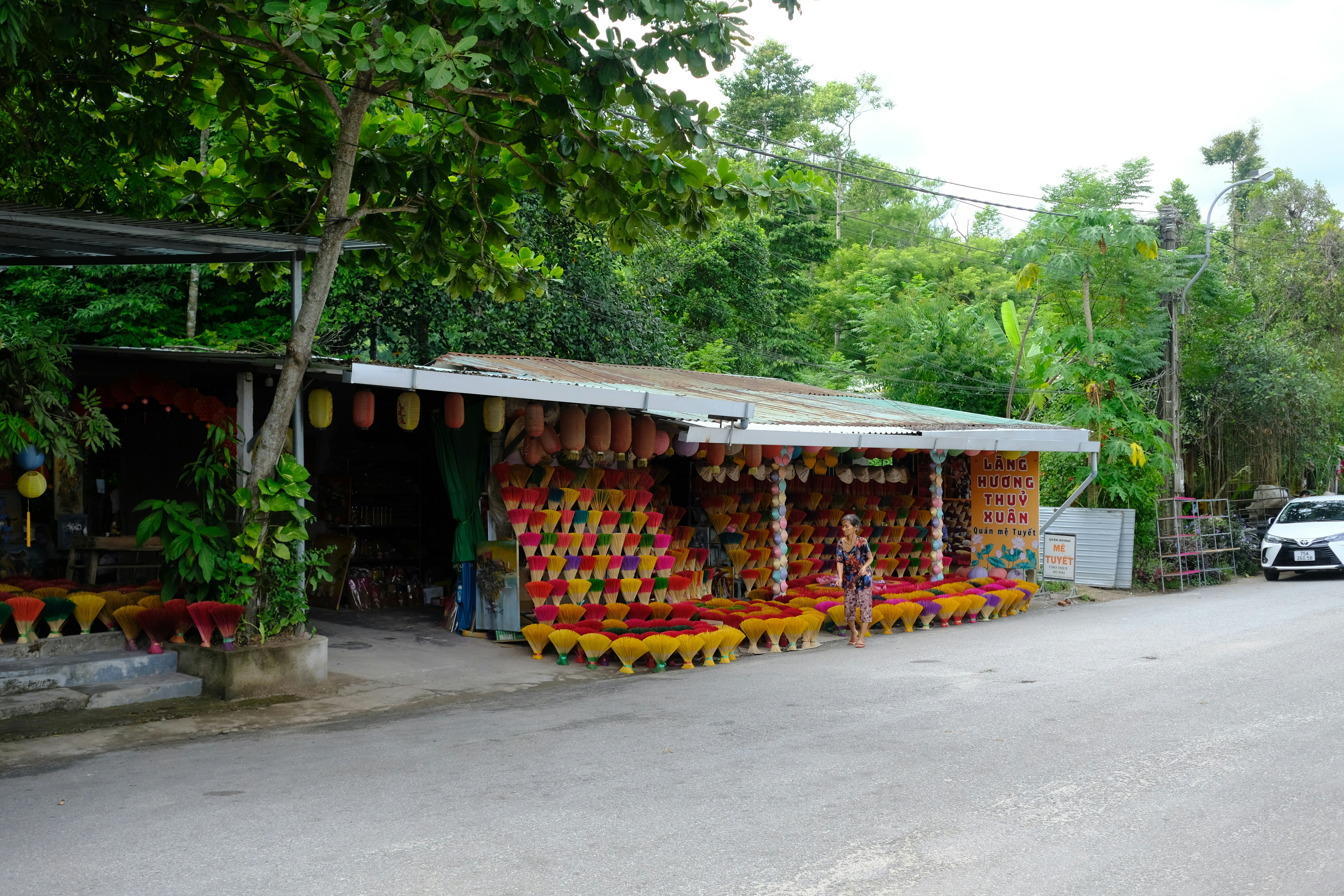 A street scene with a fruit stand on the side of the road