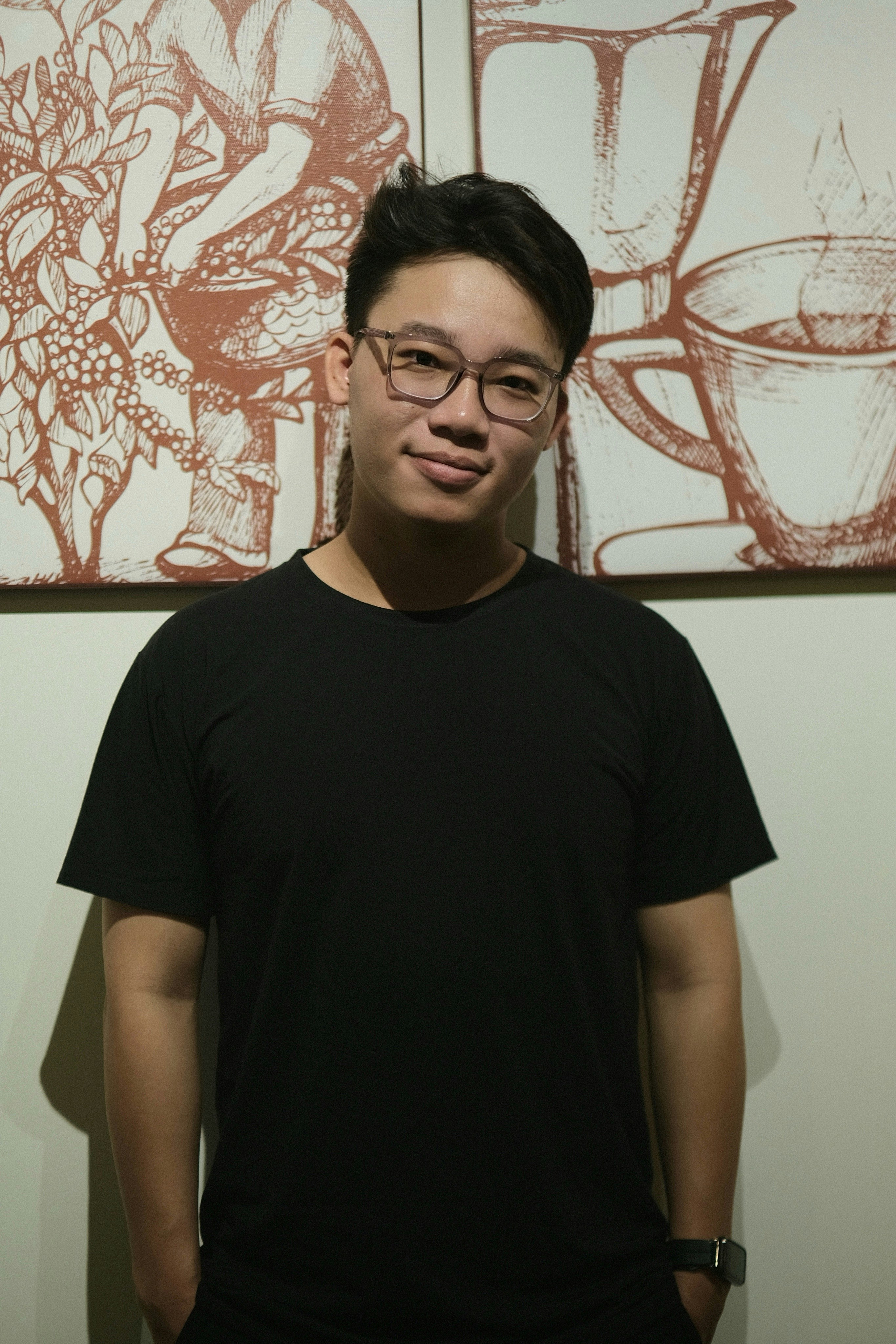 A man standing in front of two paintings