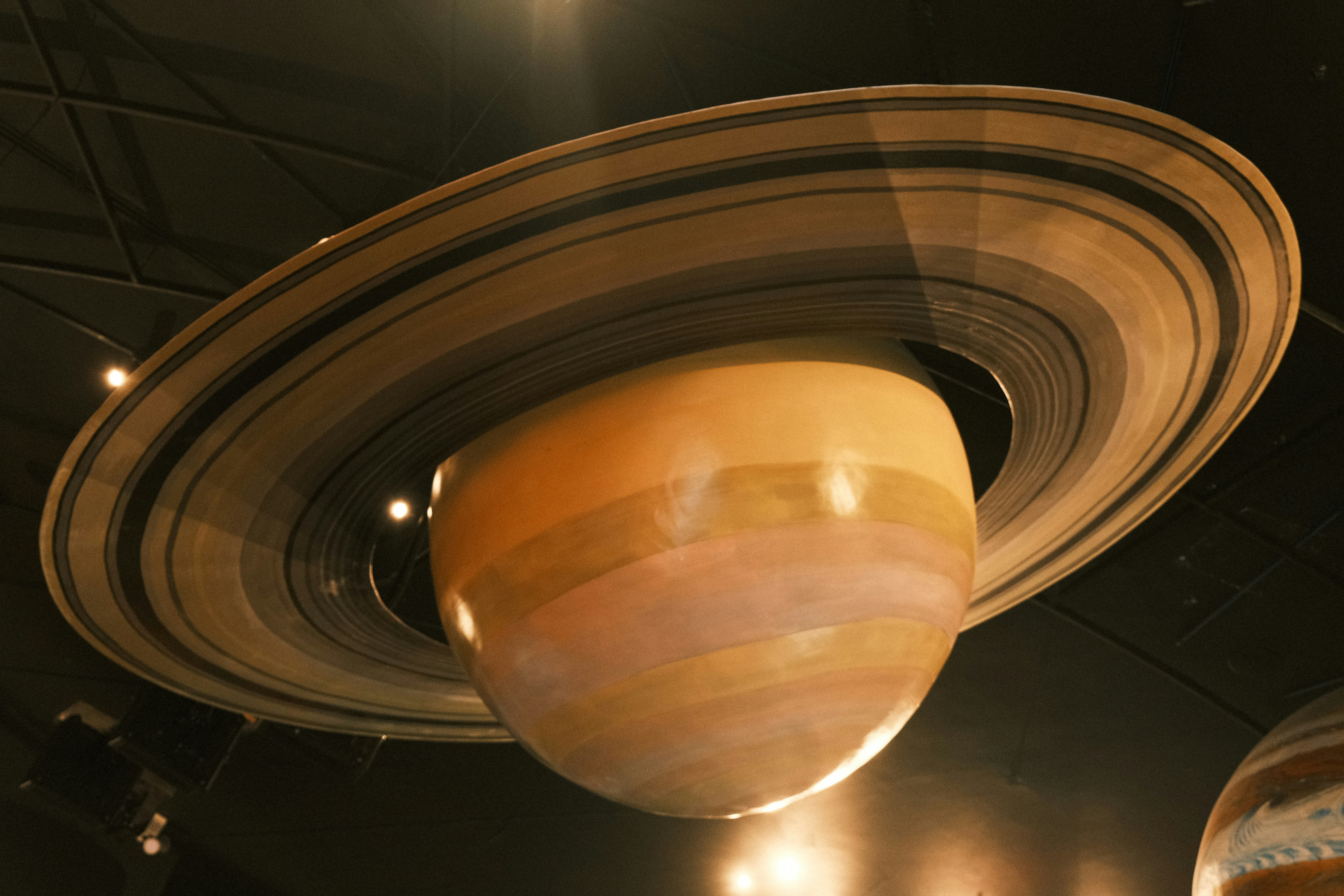 A picture of a saturn like object hanging from the ceiling