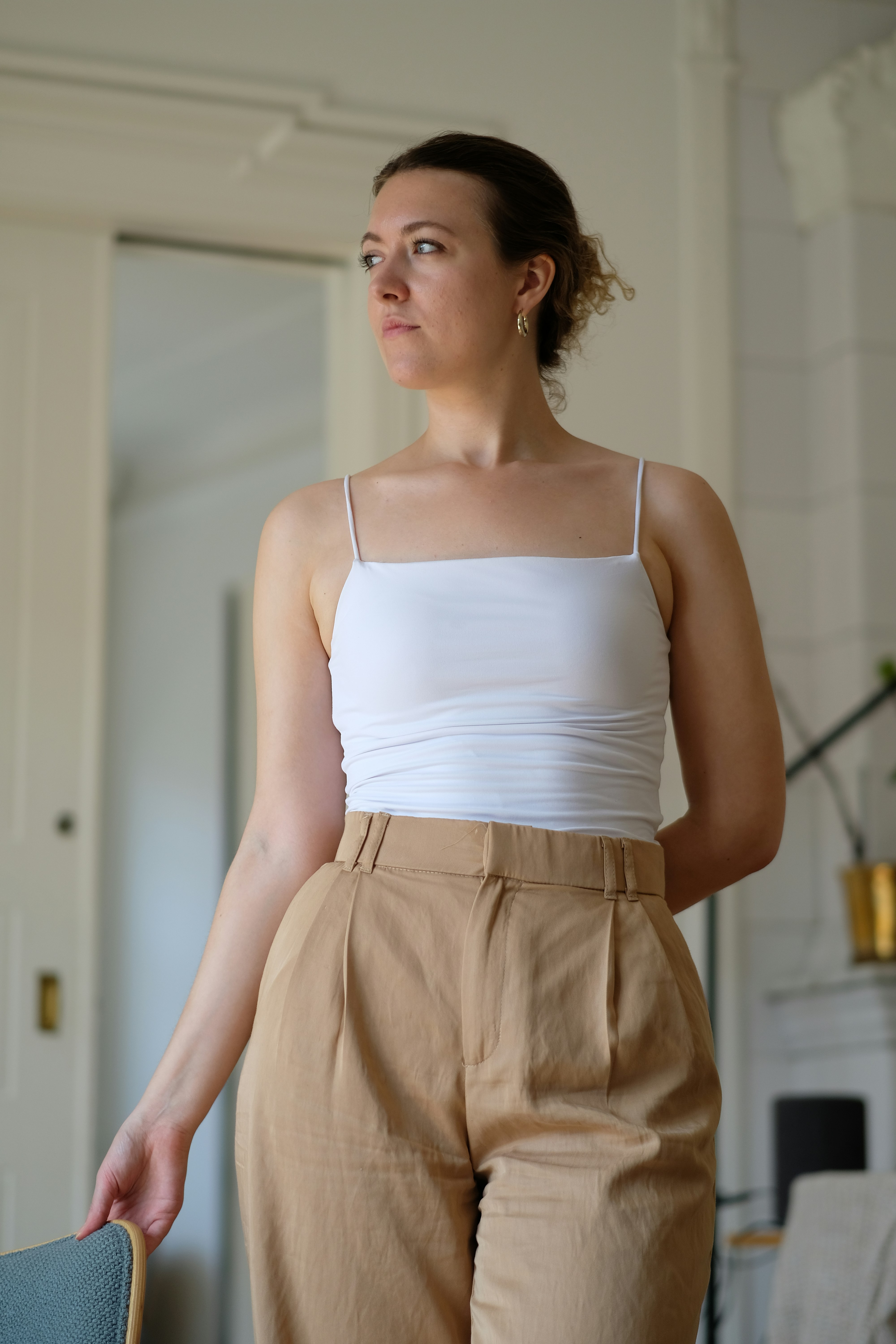 A woman standing in a room holding a skateboard