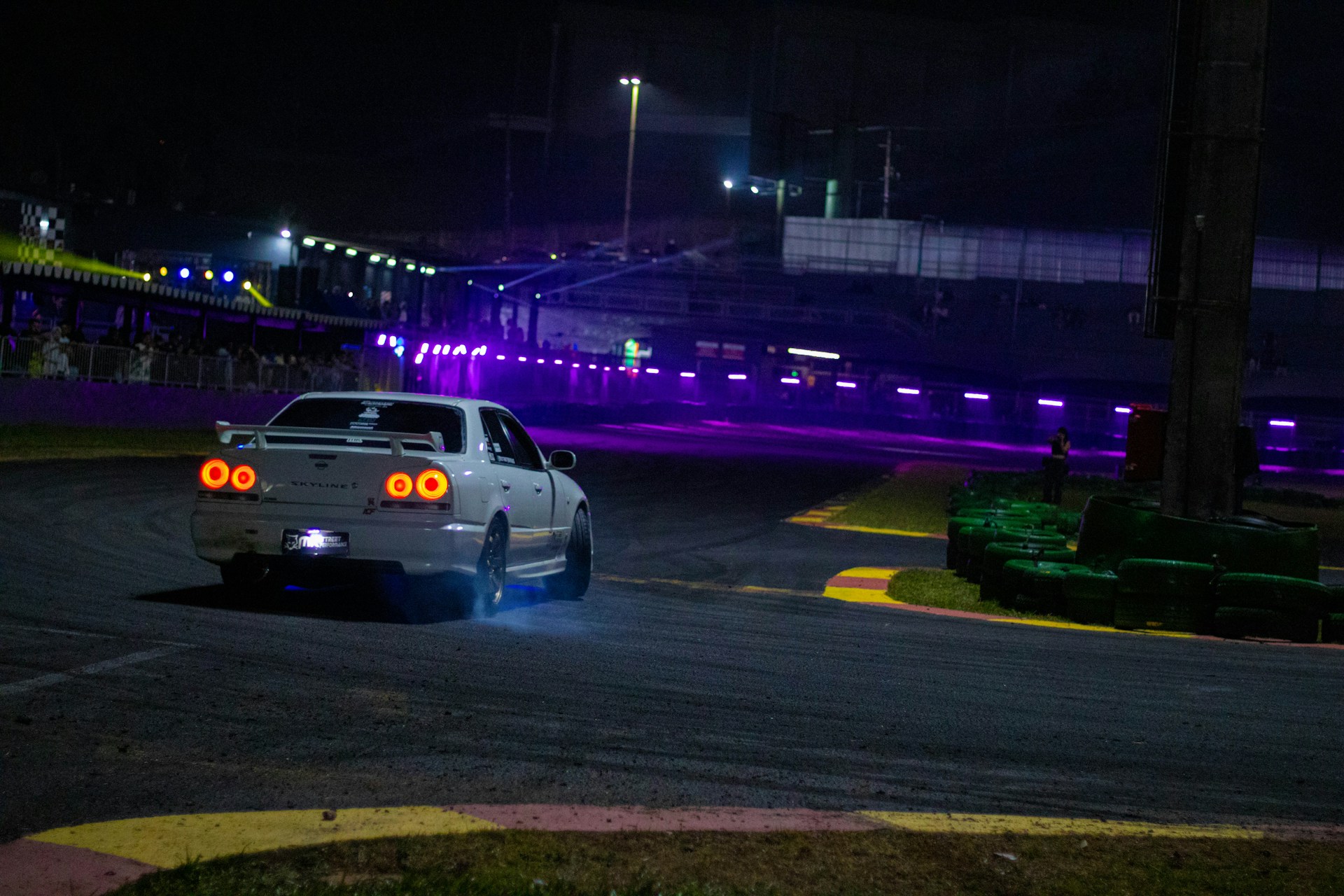 A car driving down a race track at night