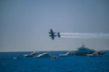 A small plane flying over a large body of water