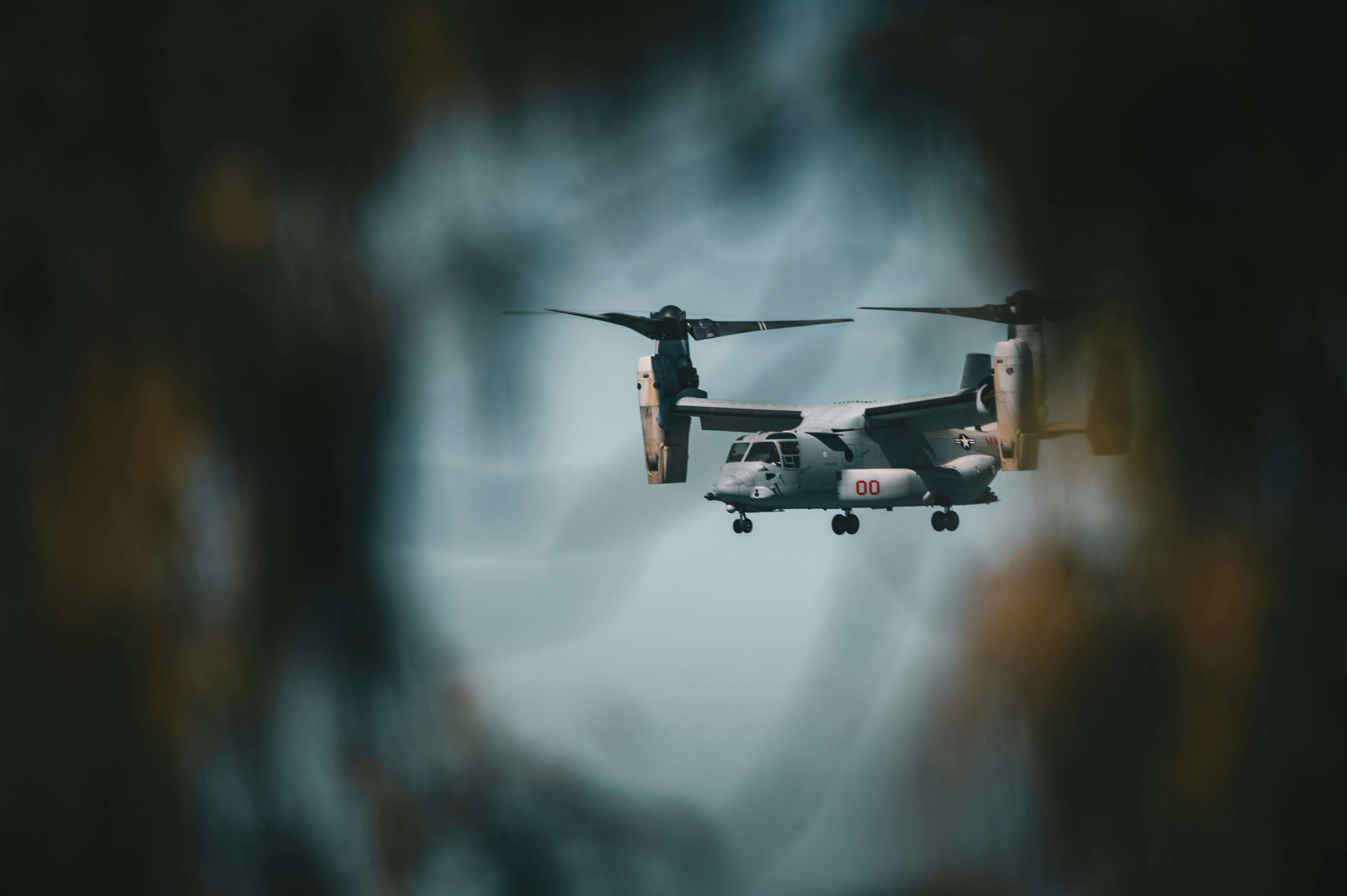 A black and white photo of a helicopter flying through the air