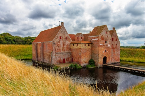 An old brick building sitting next to a body of water