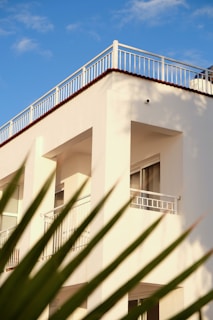 A tall white building with a balcony and balconies