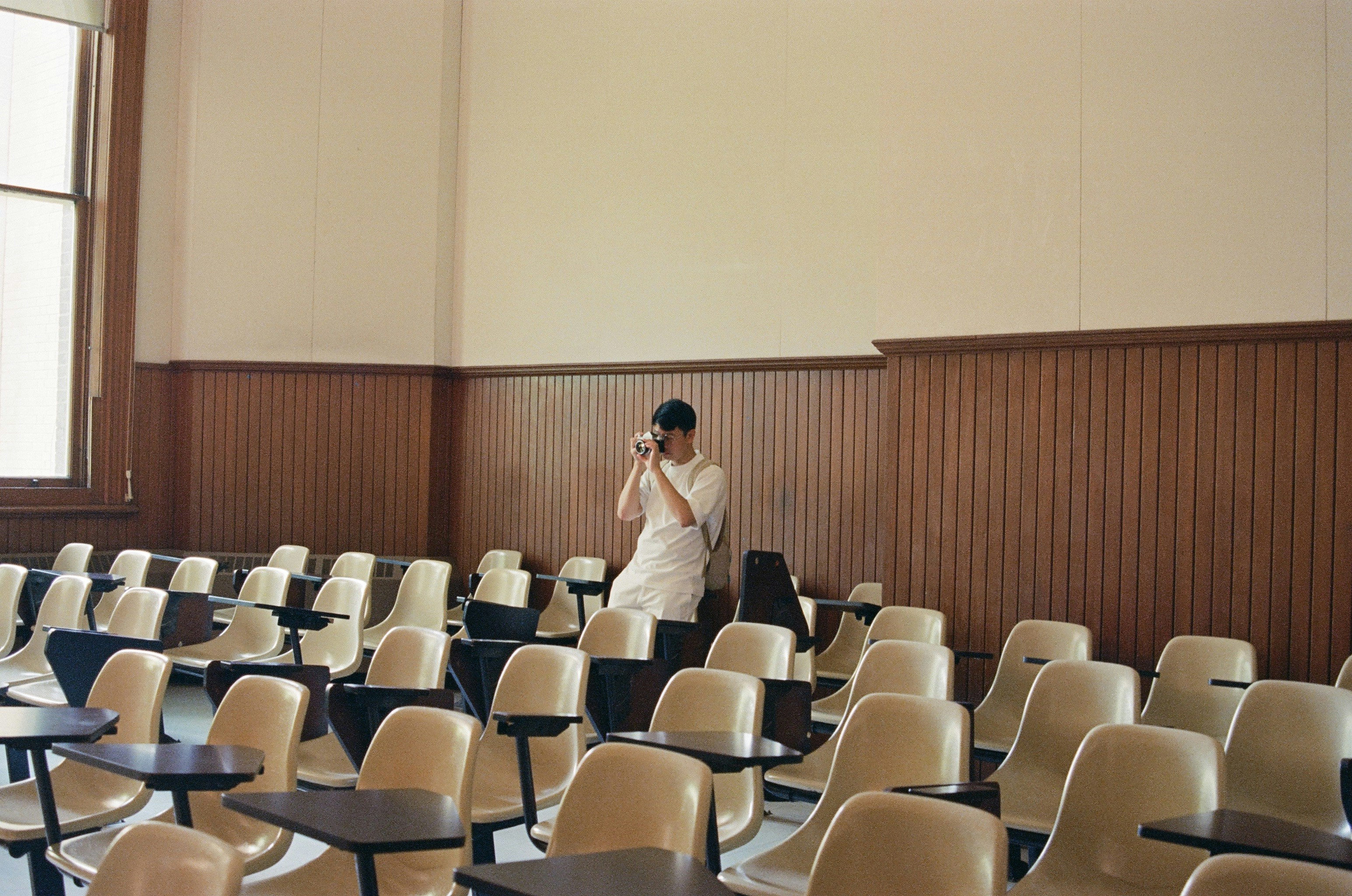 A woman standing in front of a classroom full of chairs