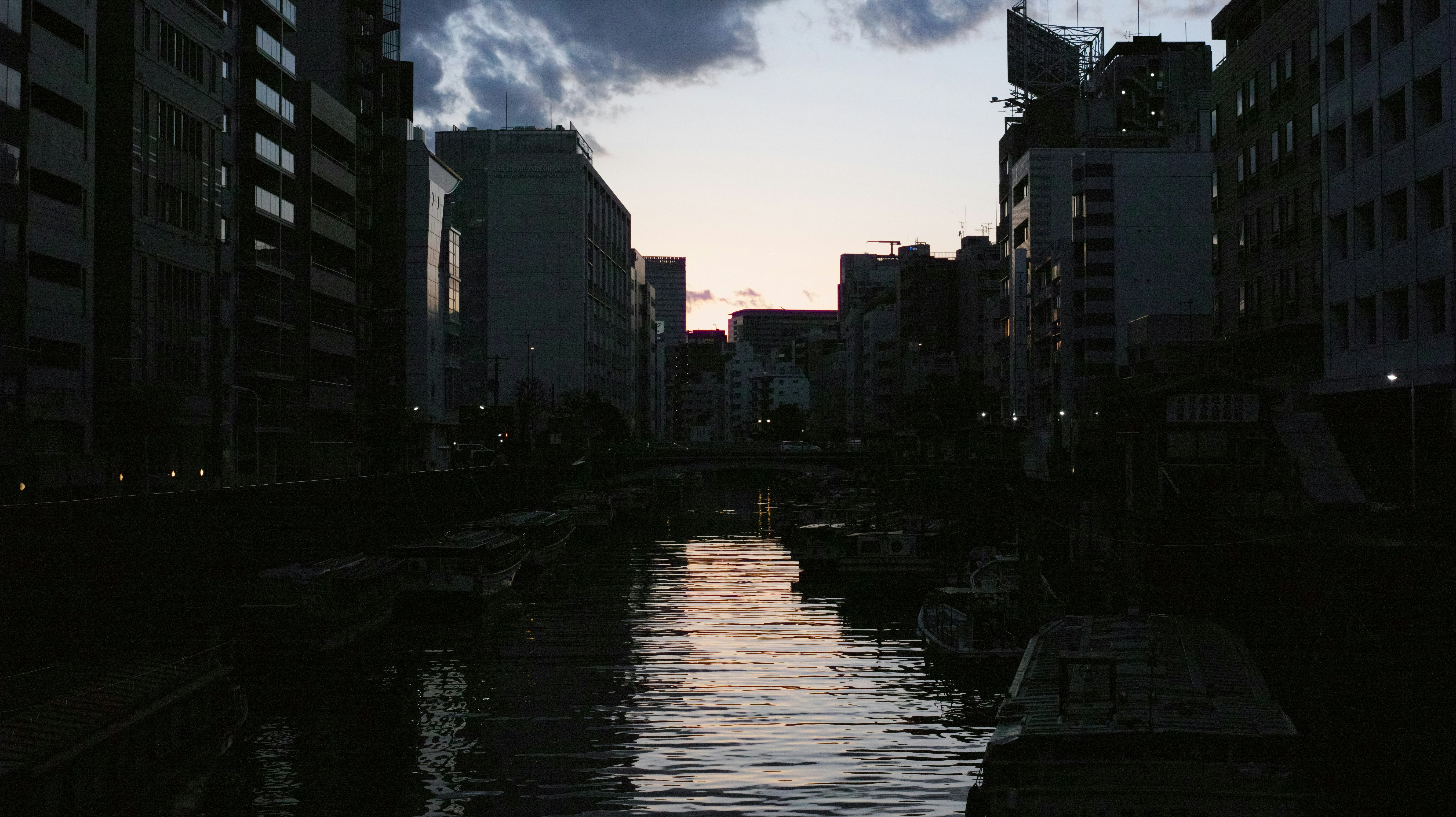 A river running through a city next to tall buildings