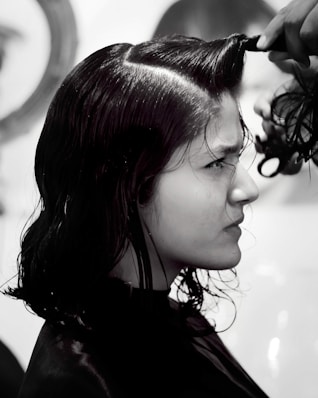 A woman getting her hair cut by a hair stylist
