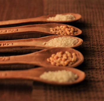 Five wooden spoons filled with different types of food