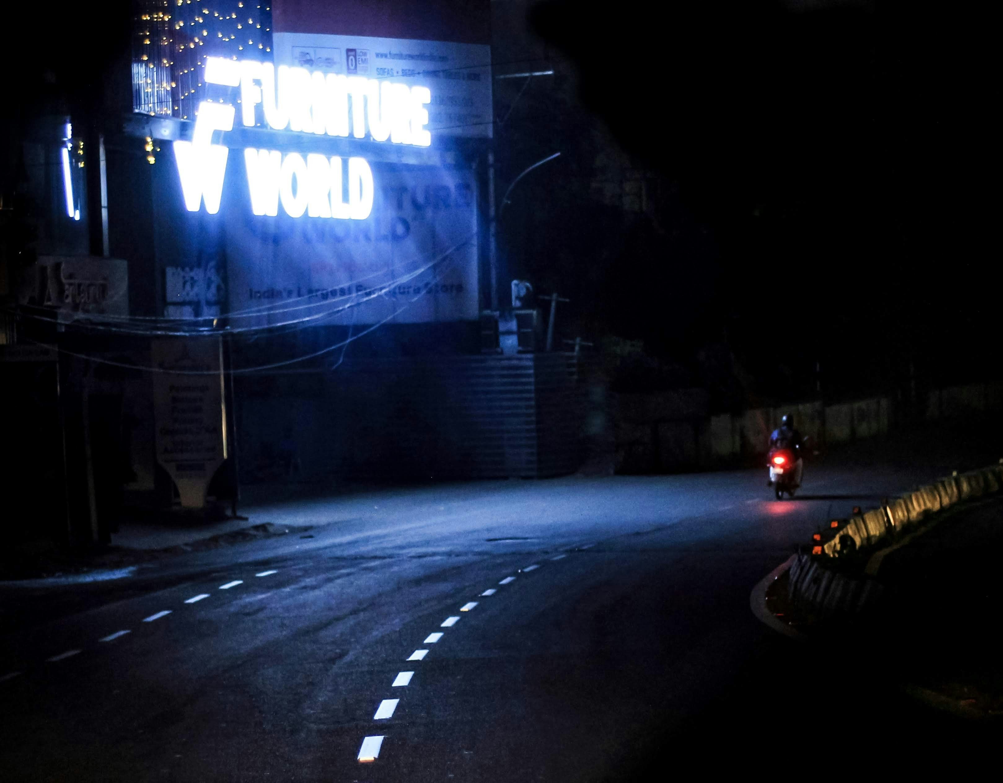 A car driving down a dark road at night