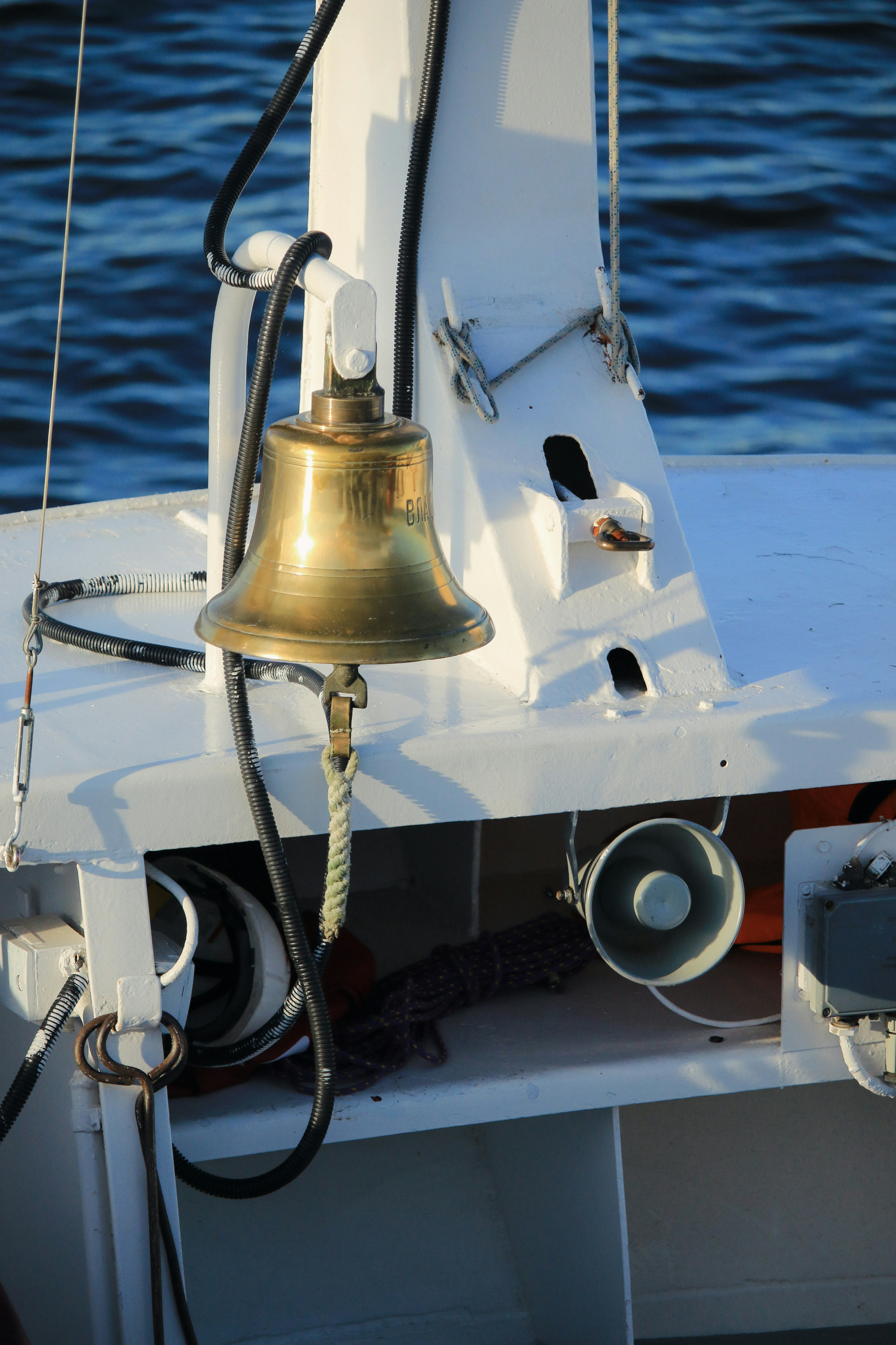 A bell on the front of a boat in the water