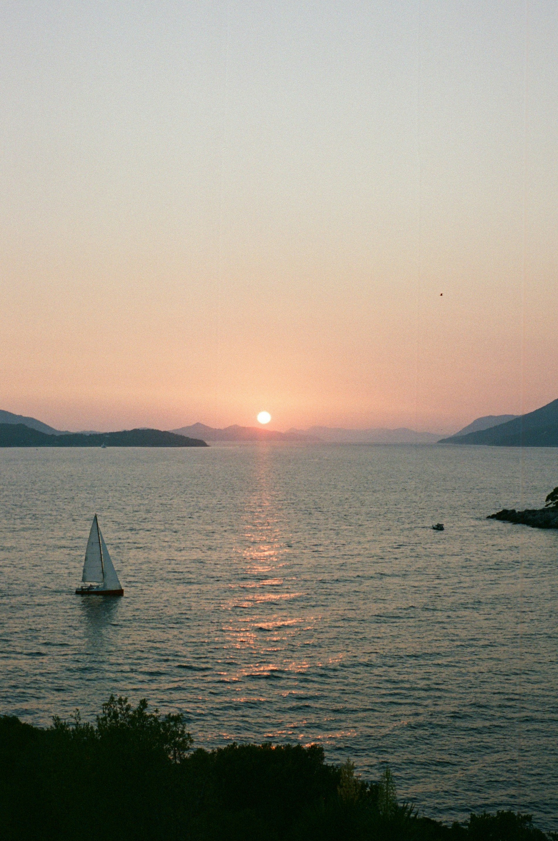 A sailboat is out on the water at sunset photo – Free Dubrovnik Image ...