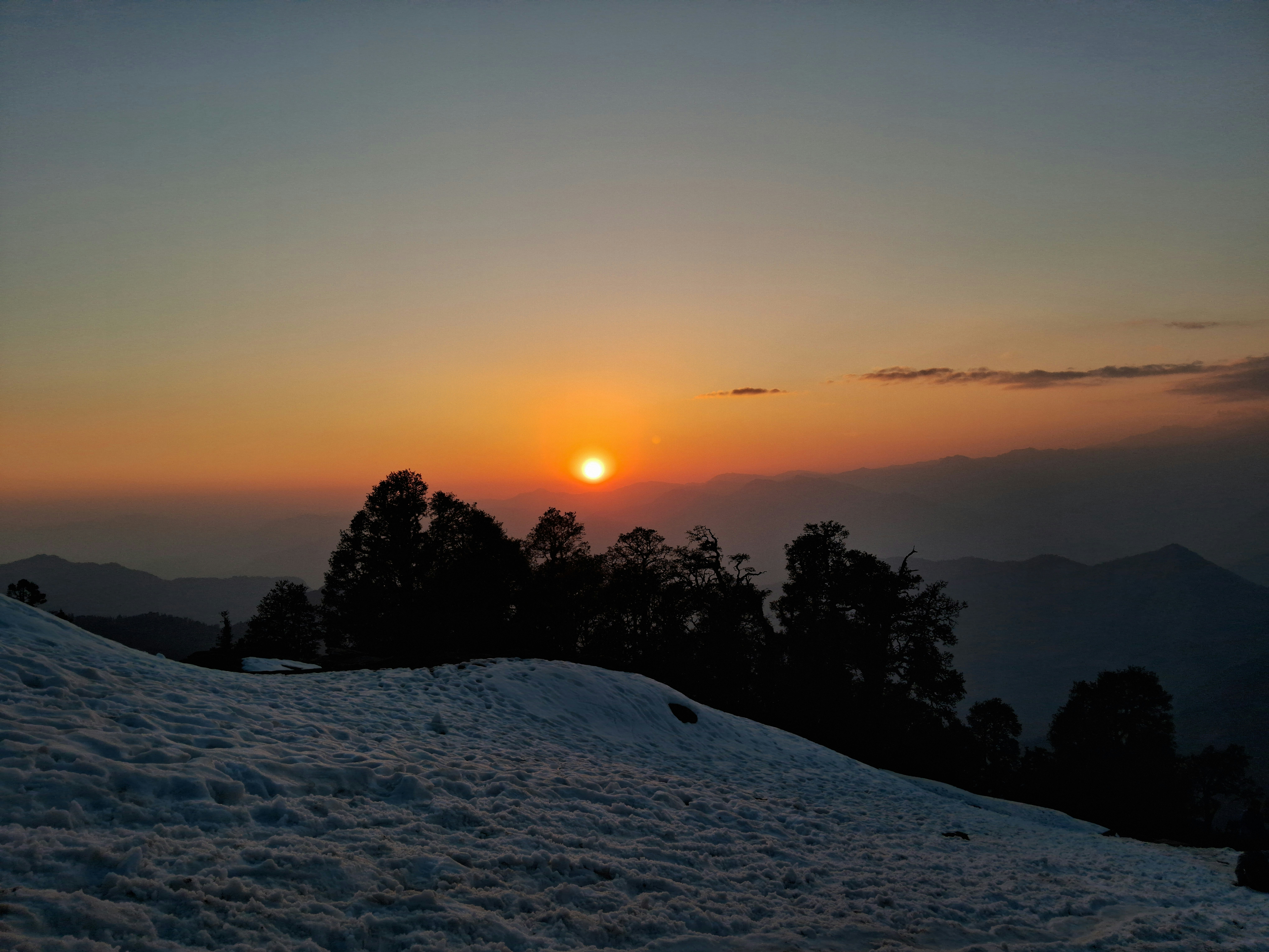 The sun is setting over a snowy hill photo – Free Sunrise Image on Unsplash