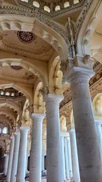 A large room with columns and a clock on the wall