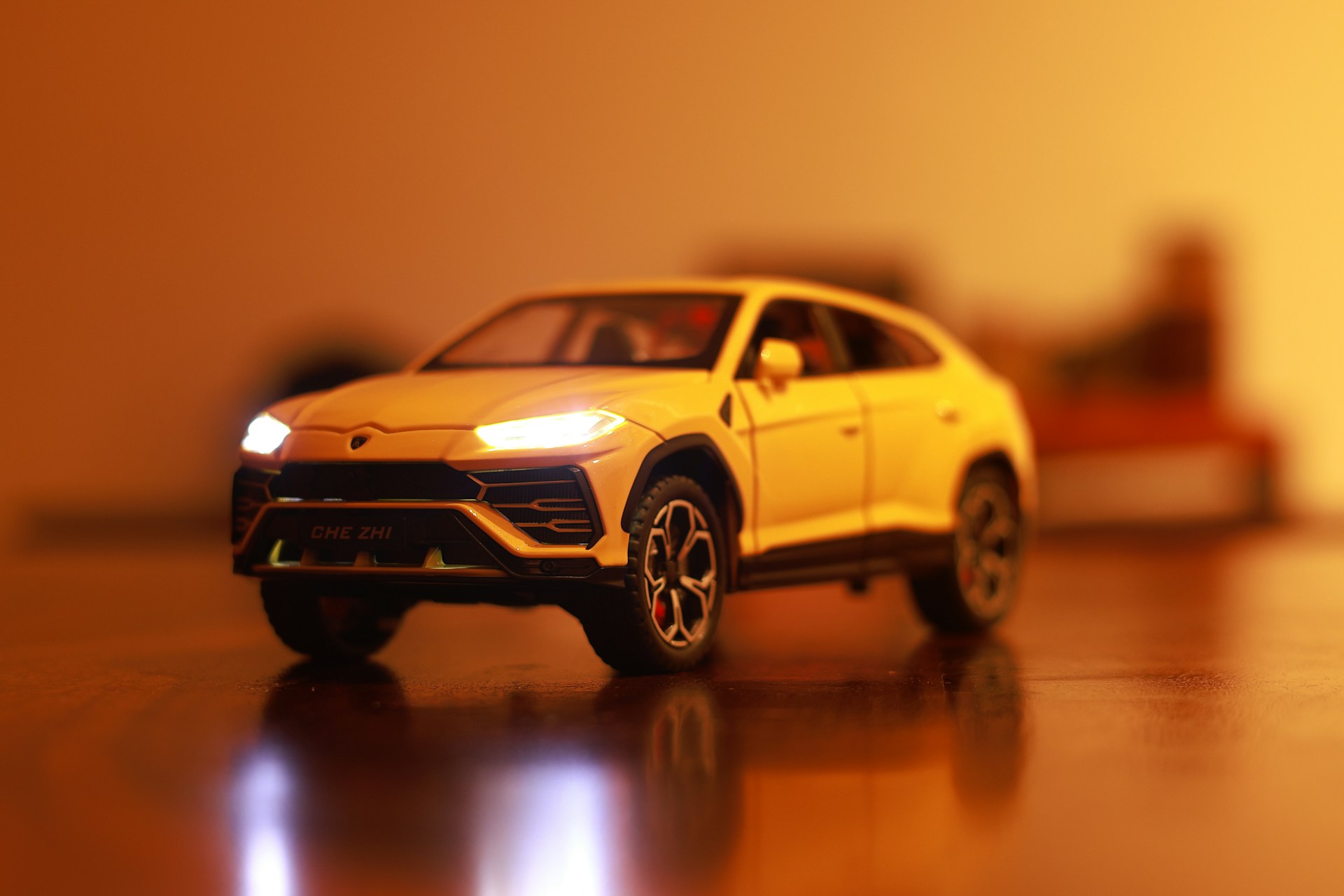 A yellow toy car on a shiny surface