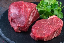 Two steaks on a plate with parsley