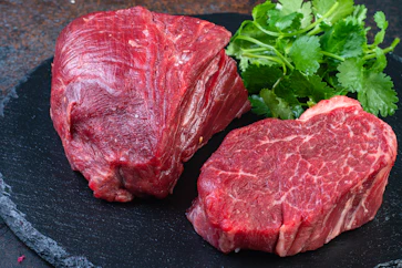 Two steaks on a plate with parsley