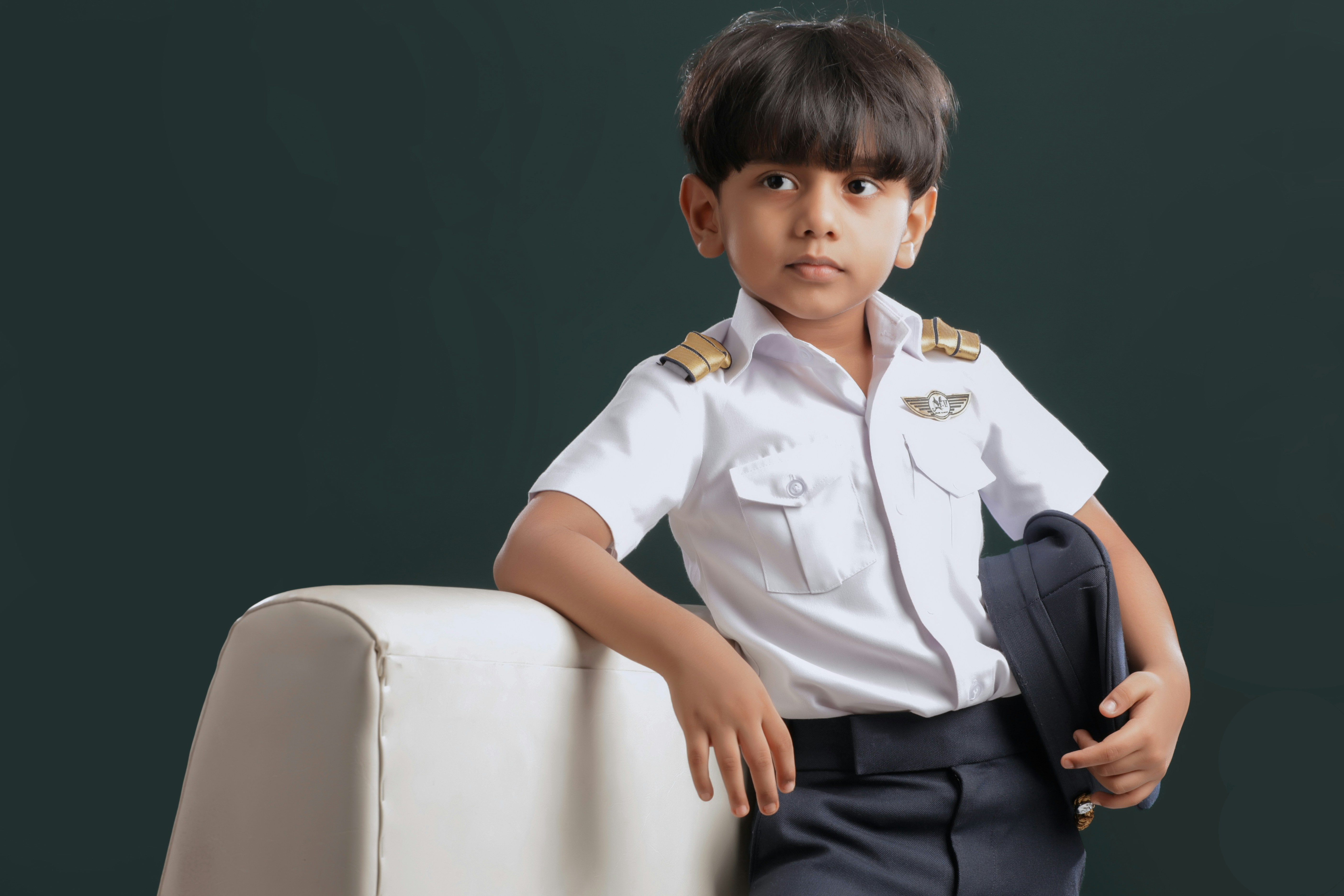 A young boy in a white shirt and blue pants