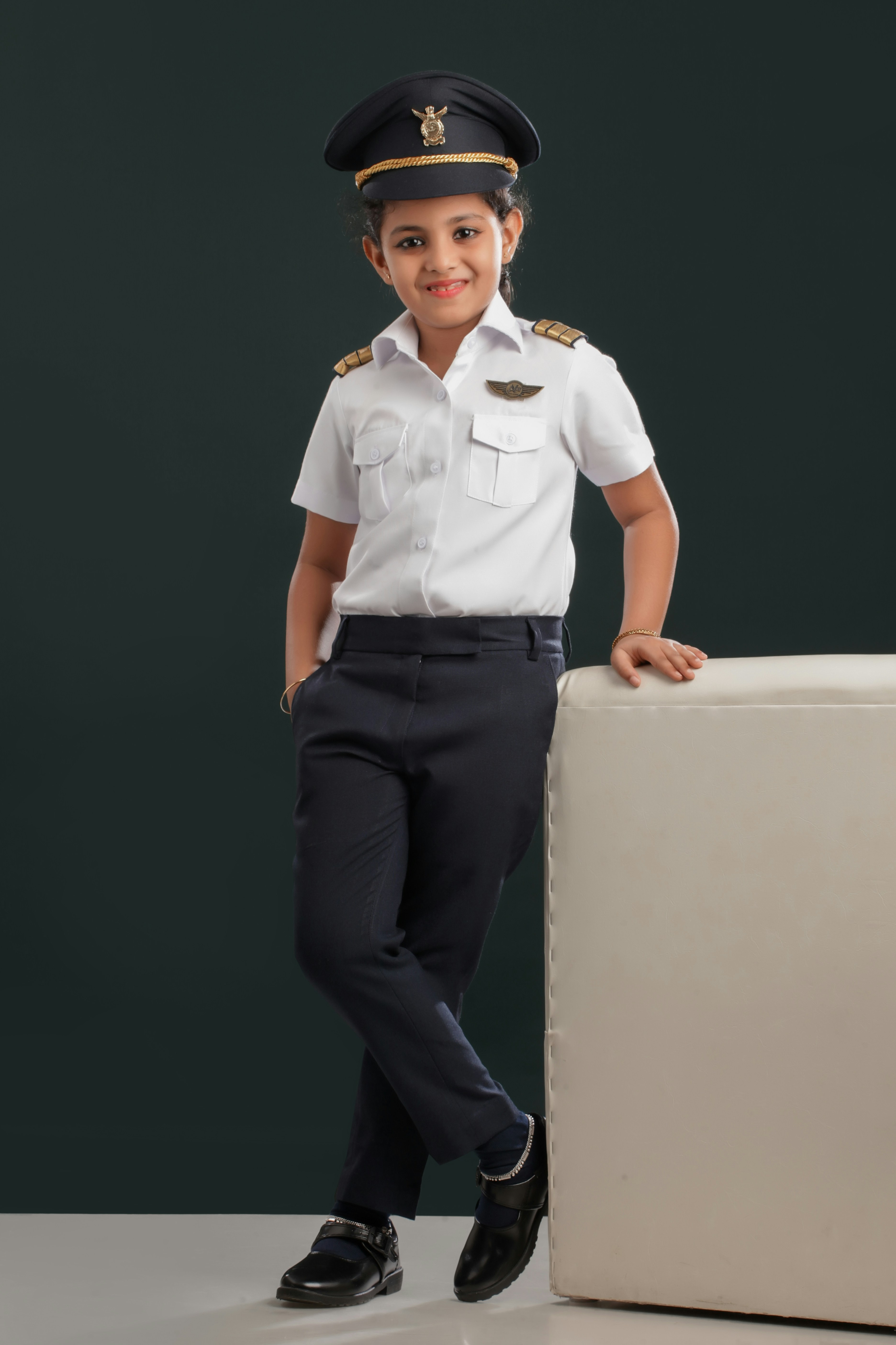 A young boy in a uniform standing next to a mattress