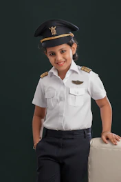A little girl dressed in a pilot's uniform