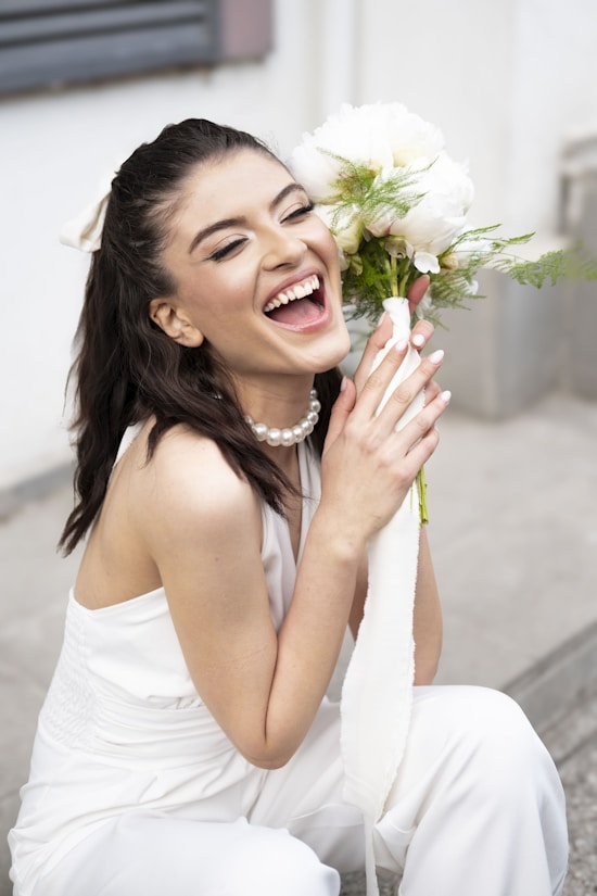 A woman sitting on the ground holding a bouquet of flowers
