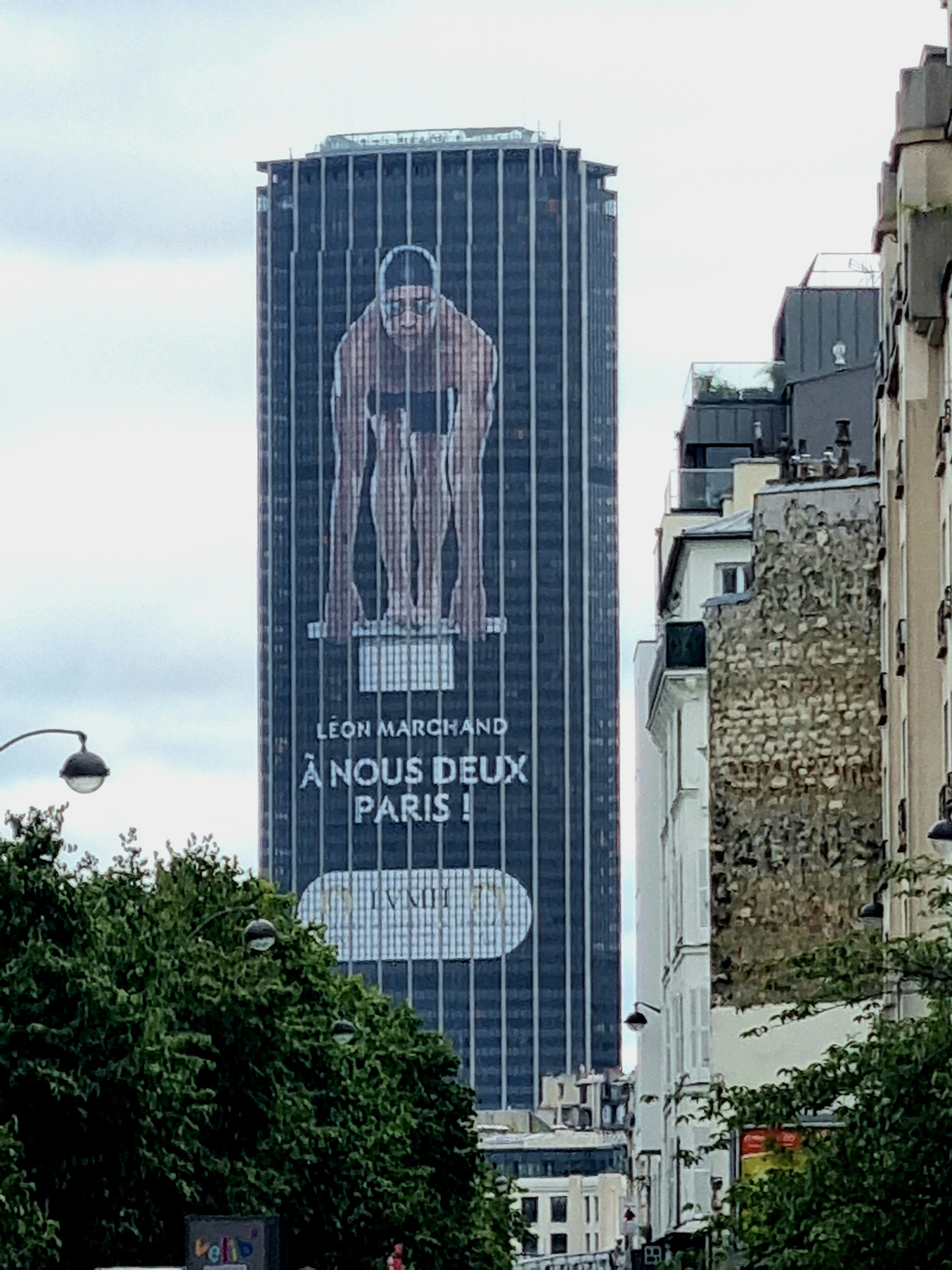 A tall building with a giant advertisement on it's side