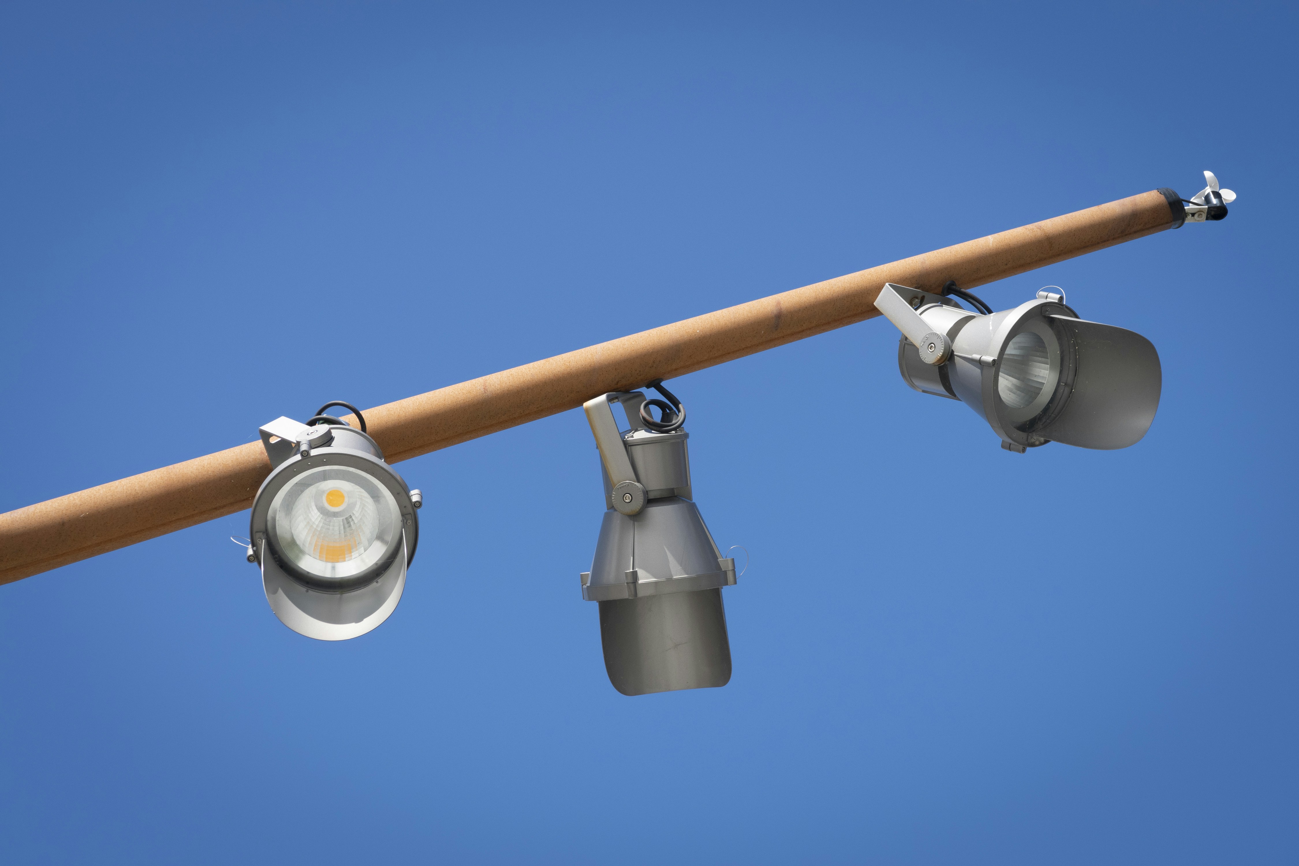 Tres focos en un poste con un cielo azul al fondo