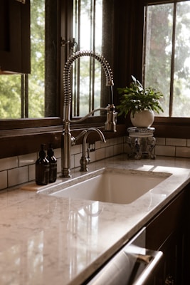 A kitchen sink sitting under a window next to a window