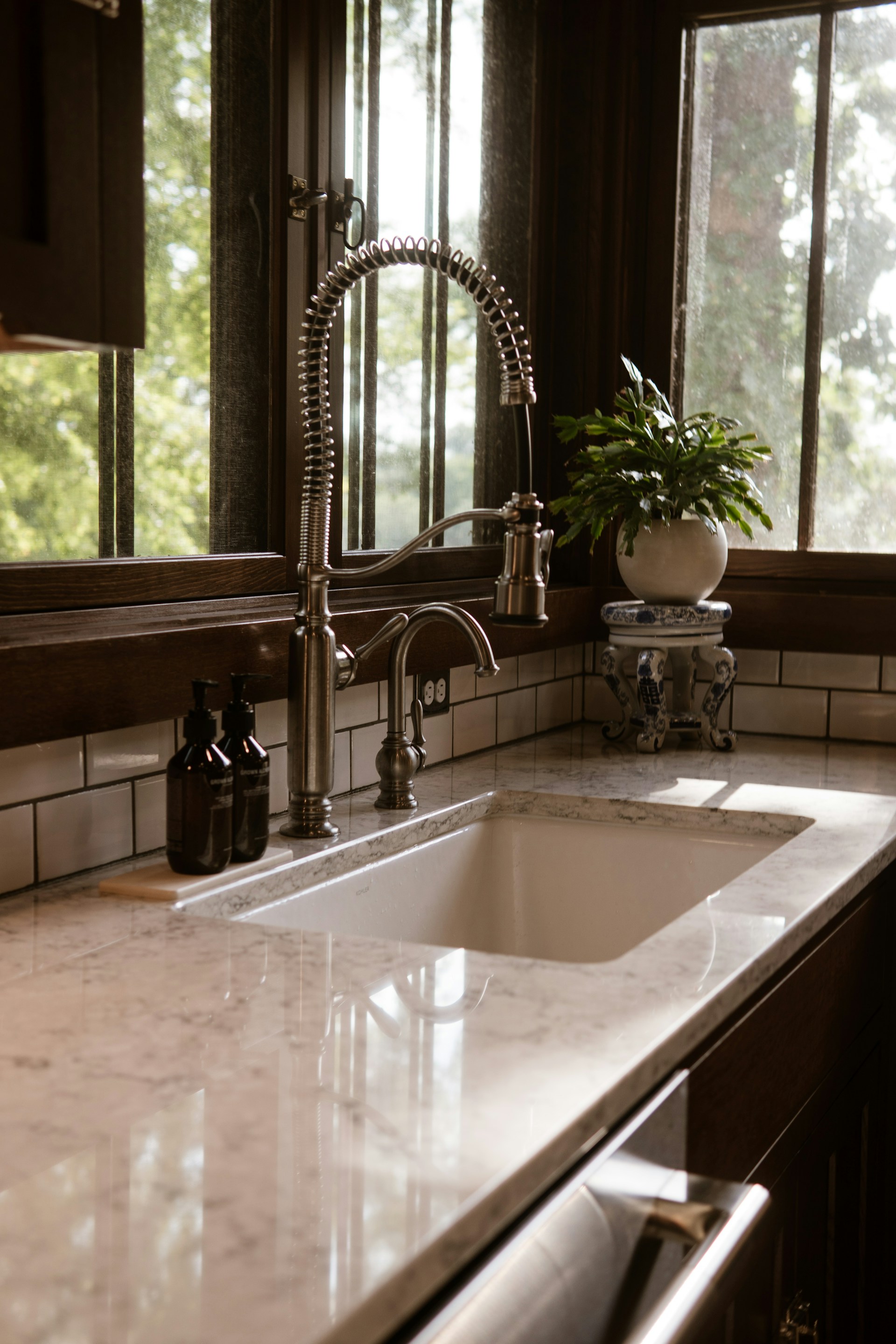 A kitchen sink sitting under a window next to a window