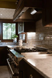 A kitchen with a stove top oven next to a sink