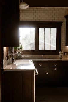 A kitchen with a sink, stove and a window