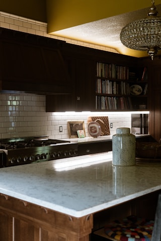A kitchen with an island and a stove top oven
