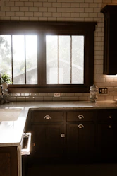 A kitchen with a sink, stove and a window