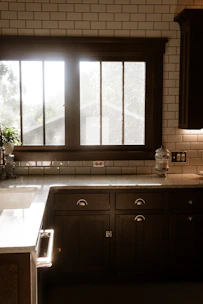 A kitchen with a sink, stove and a window