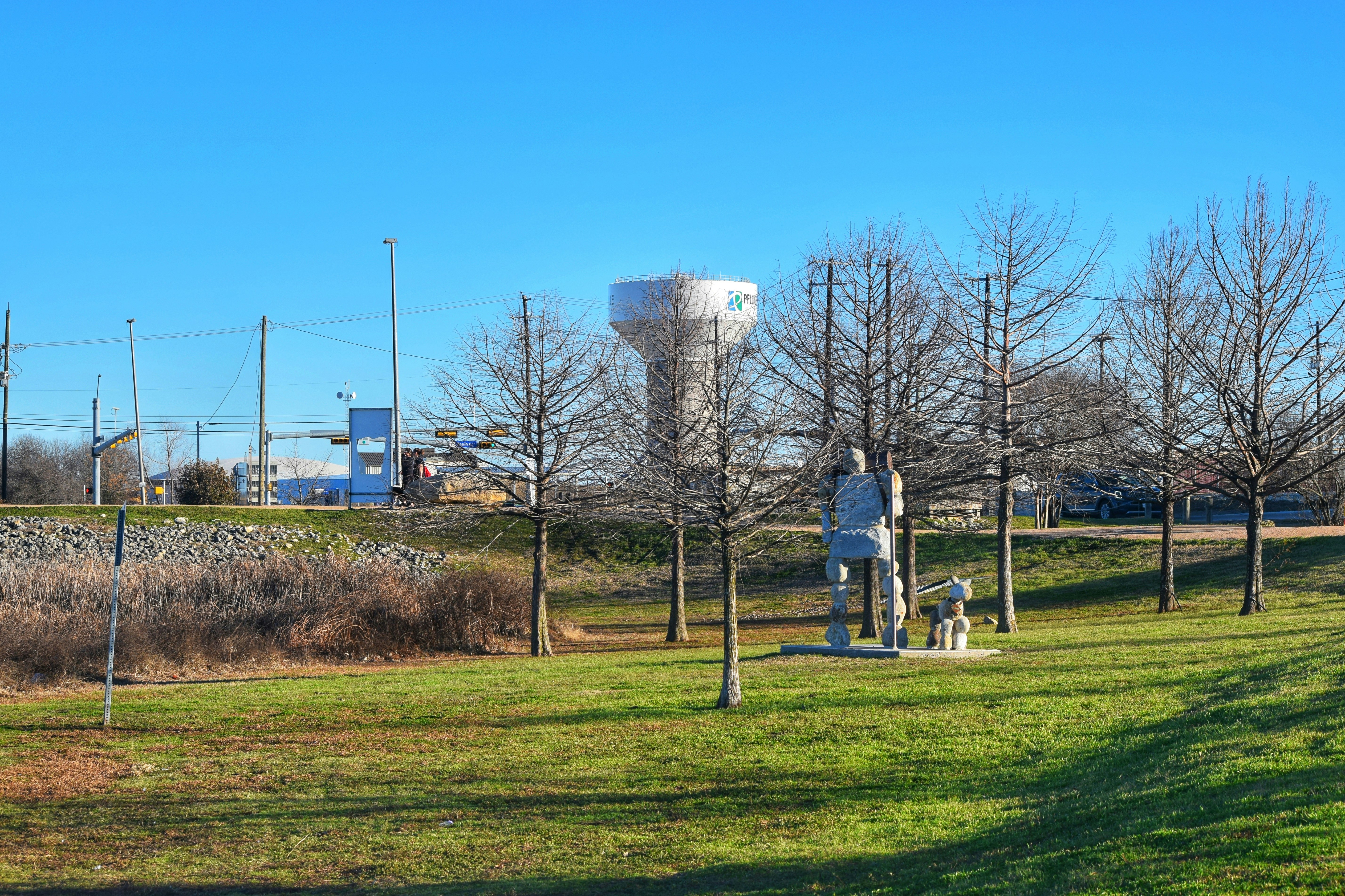 A grassy field with a water tower in the background