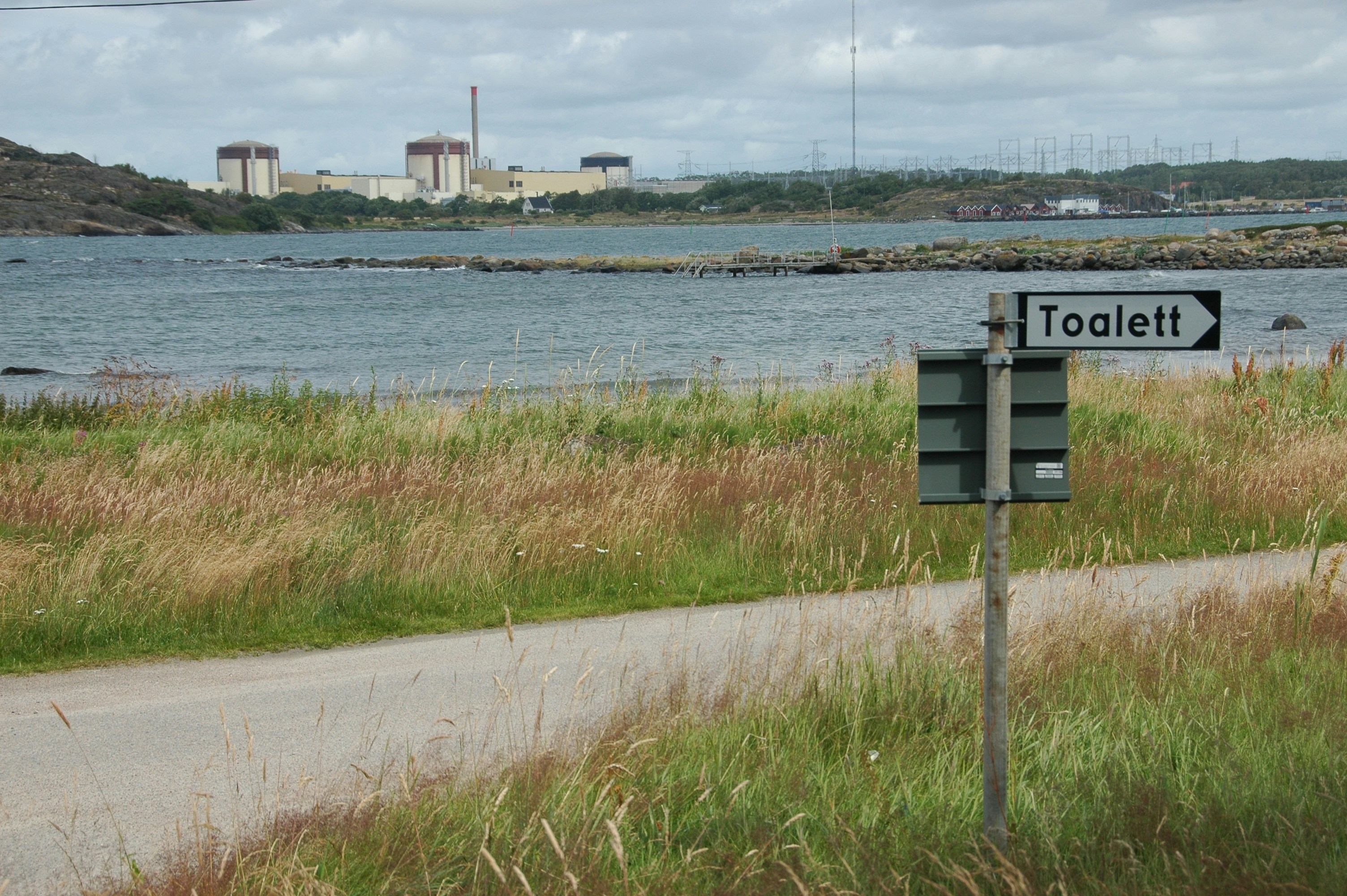 A street sign on the side of a road next to a body of water