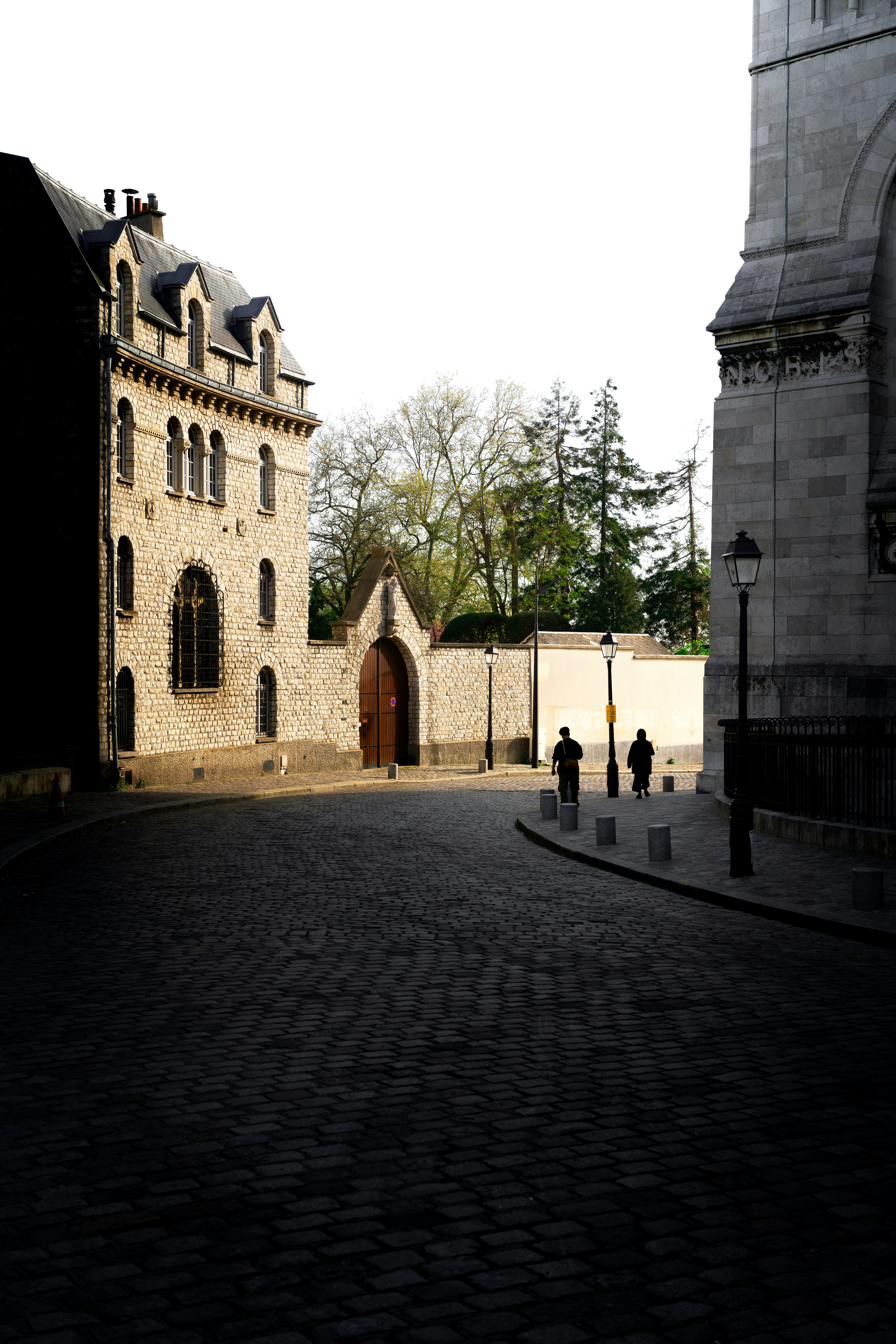 A stone building with a clock tower in the background