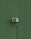 A green wall with a white and black object on it