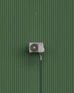 A green wall with a white and black object on it