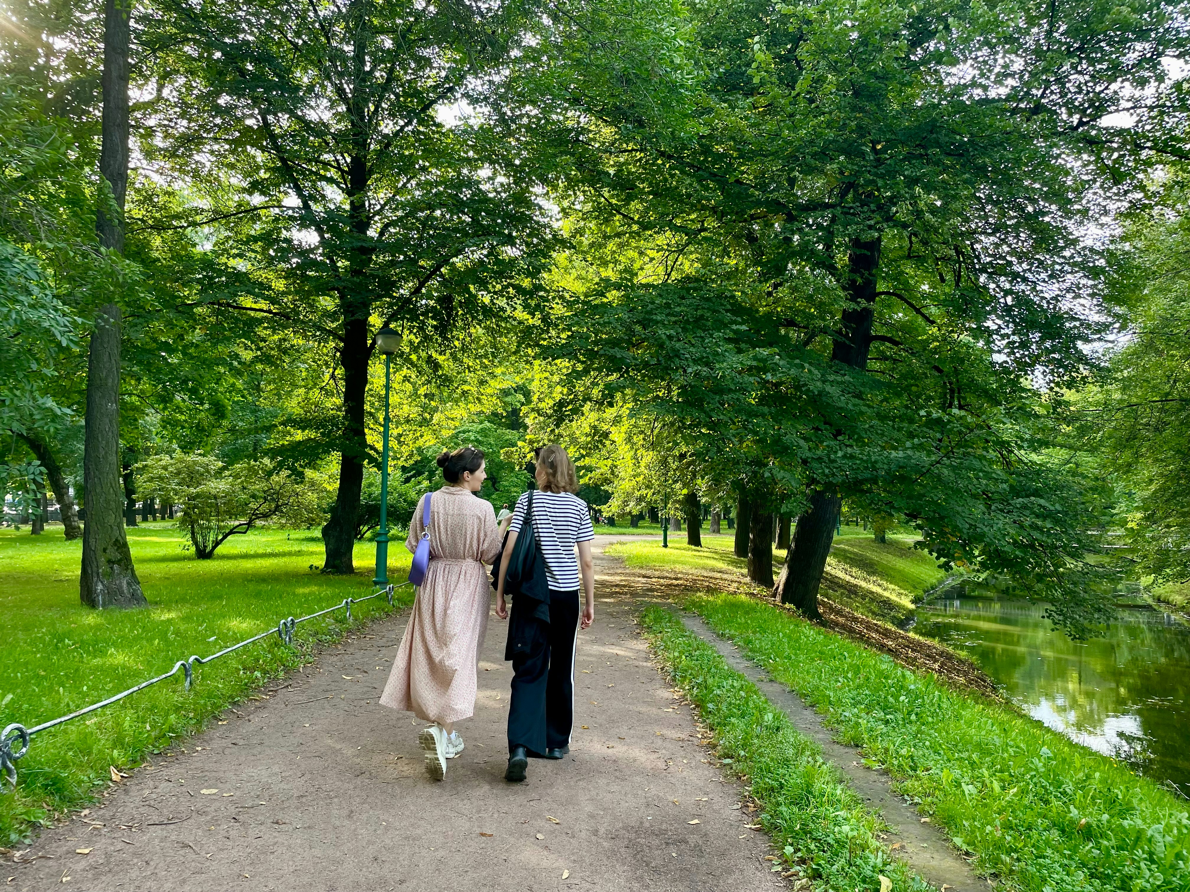 A man and woman walking down a path in a park