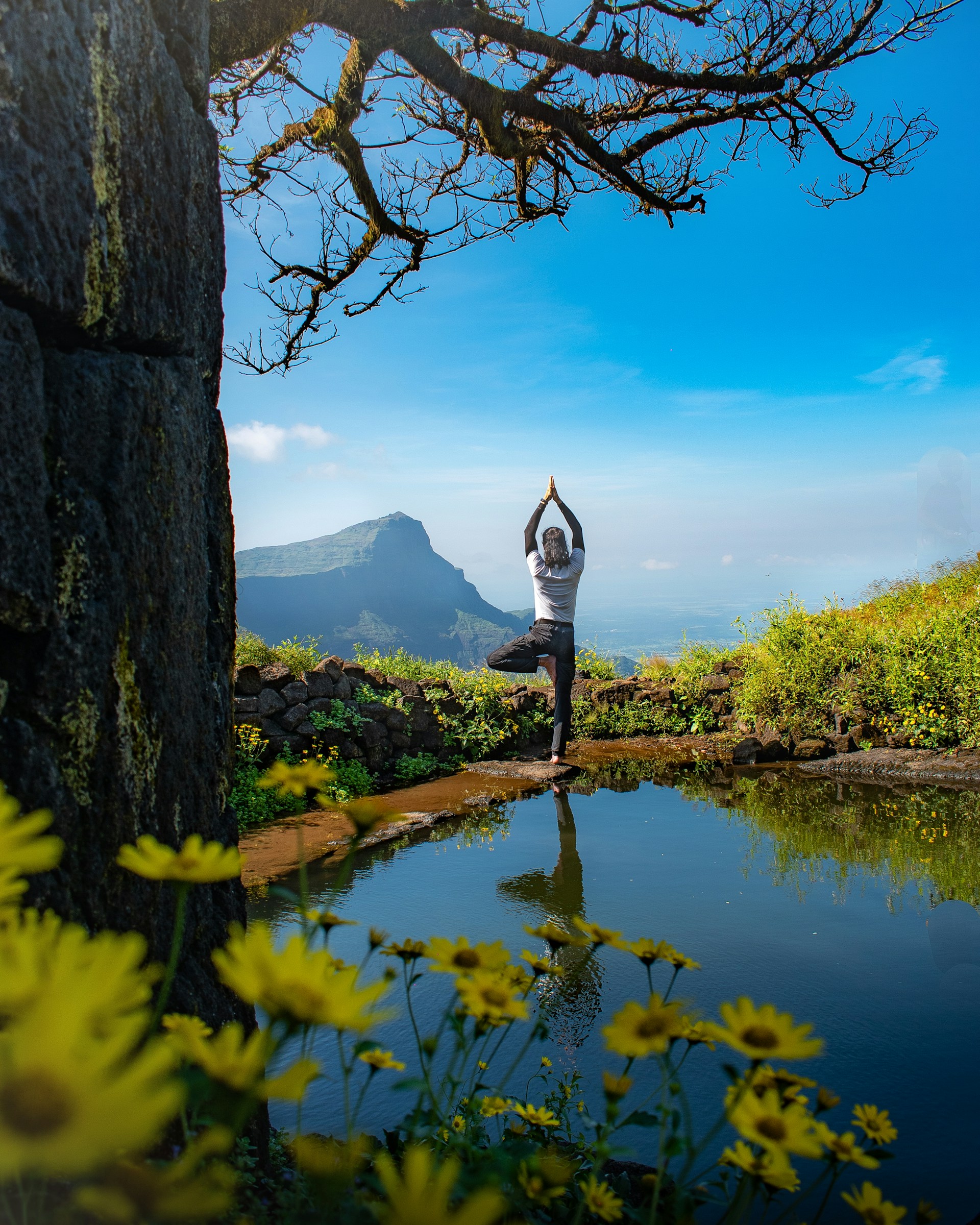 A person doing yoga in front of a lake