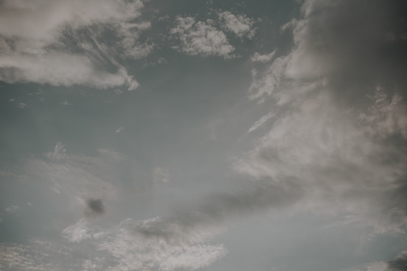 A group of people standing on top of a beach under a cloudy sky