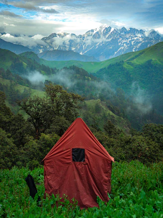 A tent in a field with mountains in the background