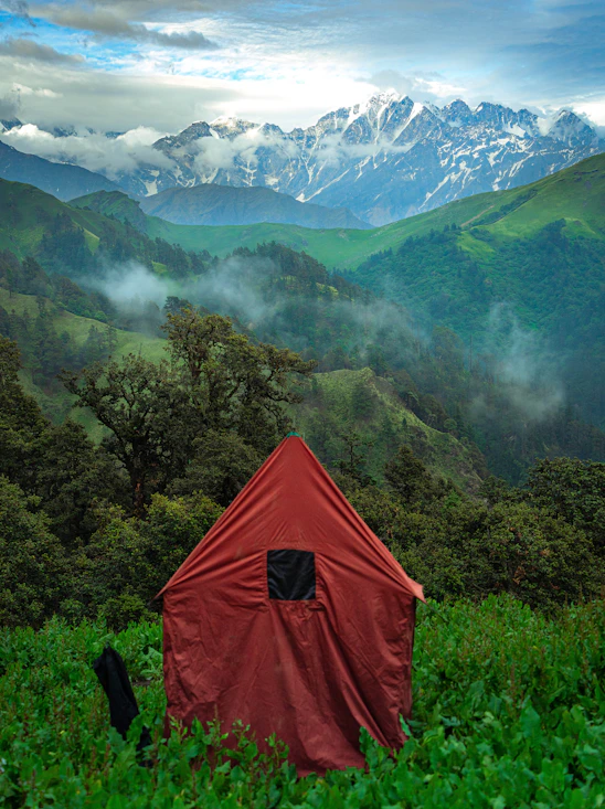 A tent in a field with mountains in the background