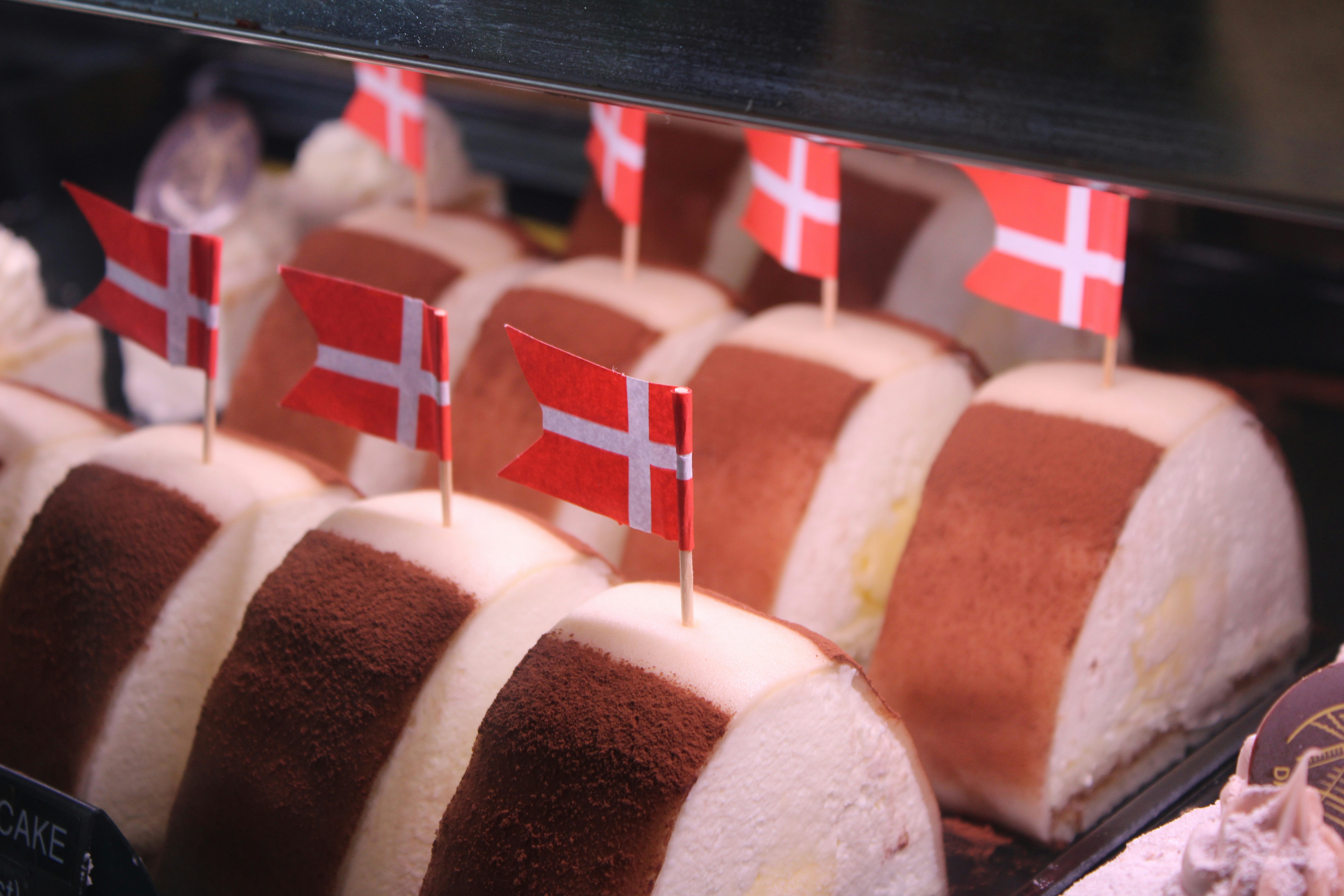 A display case filled with lots of cakes covered in frosting
